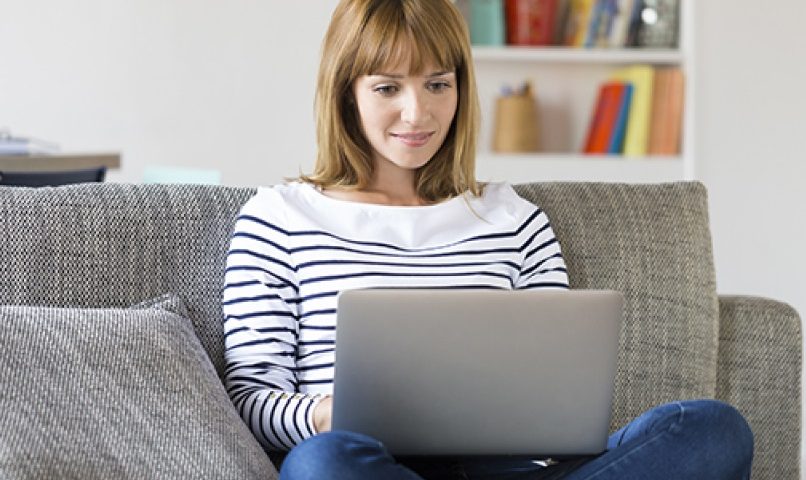 Femme dans son canapé avec ordinateur